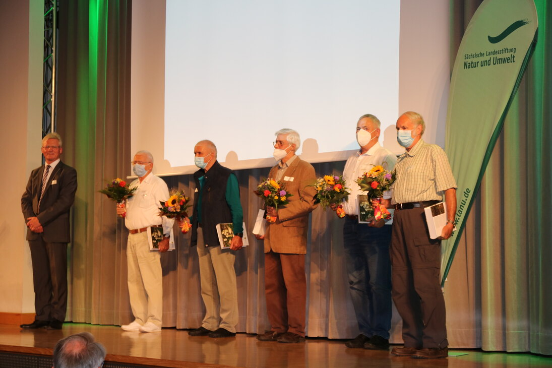 Norbert Eichkorn steht neben den fünf Pilzberatern auf der Bühne.