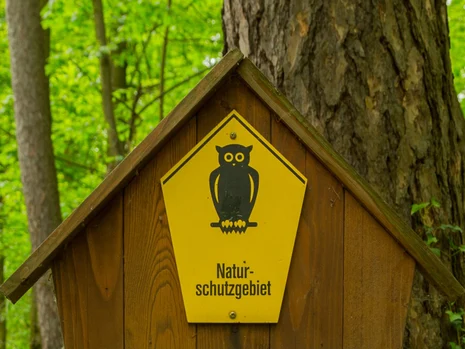 Schild »Naturschutzgebiet« mit schwarzer Eule auf gelbem Untergrund